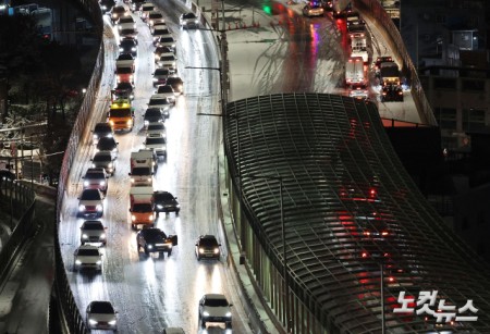 서울에 대설주의보가 내리며 내부순환로 진입로 전 구간이 통제된 가운데 4일 서울 서대문구 홍제동에서 바라본 내부순환로에 차량들이 얼어붙은 눈길을 서행하고 있다.