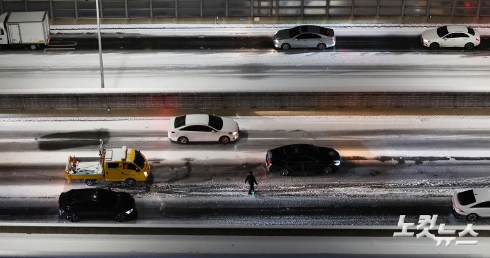 서울에 대설주의보가 내리며 내부순환로 진입로 전 구간이 통제된 가운데 4일 서울 서대문구 홍제동에서 바라본 내부순환로에 시설관리공단 직원이 제설 작업을 하고 있다.