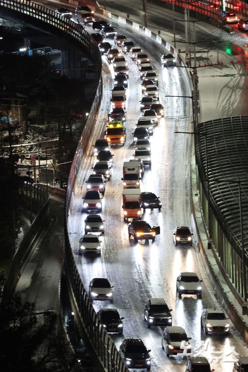 서울에 대설주의보가 내리며 내부순환로 진입로 전 구간이 통제된 가운데 4일 서울 서대문구 홍제동에서 바라본 내부순환로에 차량들이 얼어붙은 눈길을 서행하고 있다.