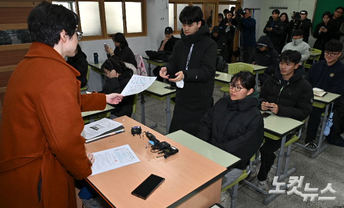 2026학년도 대학수학능력시험 성적표 배부일인 5일 오전 서울 광진구 광남고등학교에서 선생님이 학생들에게 성적표를 배부하고 있다. 류영주 기자