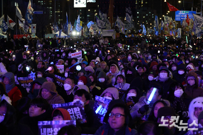 12·3 비상계엄 1년을 맞은 3일 오후 서울 영등포구 국회의사당에서 앞에서 열린 '12·3 내란·외환 청산과 종식, 사회대개혁 시민대행진' 행사에 참가한 시민들이 피켓과 응원봉을 들고 있다. 박종민 기자