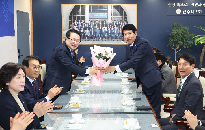 8일 전주시의회와 익산시의 간담회에서 남관우 시의장(오른쪽)이 정헌율 시장에게 꽃다발을 전달하고 있다. 전주시의회 제공