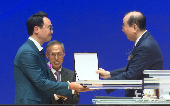 청주중앙순복음교회 김상용 원로목사가 안호성 담임목사에게 위임패를 전달하고 있다. 충북CBS