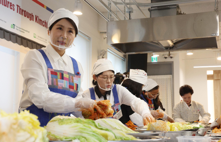 김혜경 여사가 9일 서울 종로구 북촌 한식문화공간 이음에서 열린 주한대사 배우자 초청 김장 행사에서 주한 외국대사 배우자들과 함께 김치를 담그고 있다. 연합뉴스