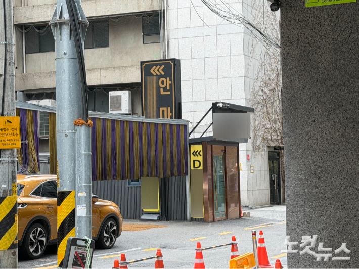 강남 소재의 S 안마소 앞에 다른 상호명이 적힌 간판들이 달려 있다. 상호명은 다르지만 화살표는 같은 건물을 가리키고 있다. 박준현 기자