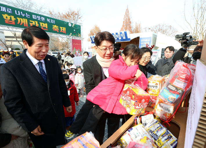 10일 '전주와 함께라면 축제' 현장을 찾은 우범기 전주시장(가운데)이 한 어린이와 함께 라면을 기부하고 있다. 전주시 제공