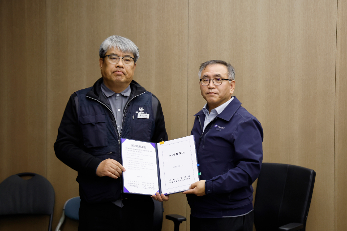 김태균 민주노총 공공운수노조 서울교통공사노조위원장(왼쪽)과 한영희 서울교통공사 기획본부장(사장 직무대행)이 12일 서울 성동구 서울교통공사 본사에서 임금·단체협약 합의서를 체결한 뒤 기념 촬영하고 있다. 연합뉴스