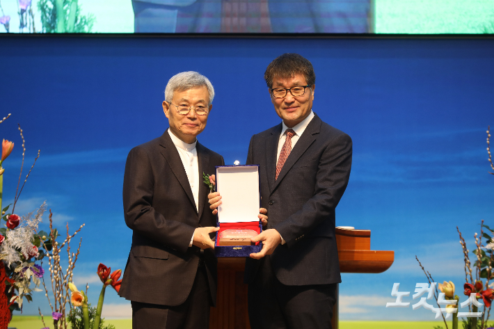 임권희 장로가 홍동필 원로목사에게 감사패를 전달하며 그간의 헌신에 감사를 전하고 있다. 최화랑 기자