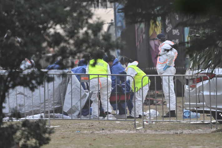 15일(현지시간) 호주 시드니 본다이 해변에서 발생한 총기 난사 사건 현장에 수사관들이 도착해 조사하고 있다. 연합뉴스