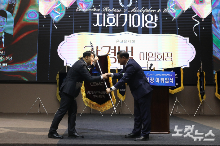 제24대 강경범 회장이 제25대 오정현 신임 회장에게 CBMC 전북연합회 지회기를 이양하고 있다. 최화랑 기자