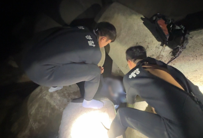 테트라포드 사이로 추락한 20대 남성을 구조하고 있는 모습. 동해지방해양경찰청 제공