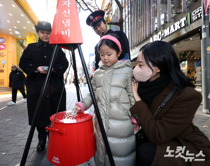 2025 구세군 연말 모금 캠페인이 시작된 지난달 28일 오후 서울 명동거리에서 한 어린이가 구세군 냄비에 성금을 기부하고 있다. 황진환 기자