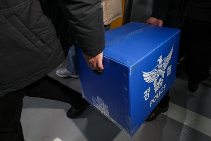 9일 서울 송파구 쿠팡 본사에서 압수수색을 마친 경찰 관계자들이 상자를 들고 이동하고 있다. 연합뉴스