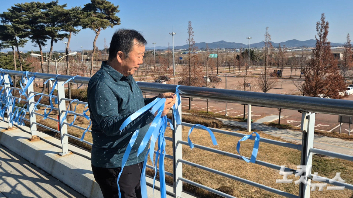 무안국제공항 외부에 파란 리본을 달고 있는 박인욱 씨. 한아름 기자