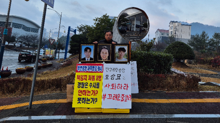 김영헌 씨가 지난 11일 전남경찰청 앞에서 1인 시위를 하고 있다. 이날은 사고로 떠나보낸 아내와 두 아들의 사진을 들고 시위에 나섰다. 김영헌 씨 제공