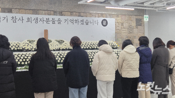 22일 오후 광주 동구 전일빌딩245 1층에 마련된 여객기 참사 희생자 합동분향소에 시민들이 헌화 후 묵념하고 있다. 한아름 기자