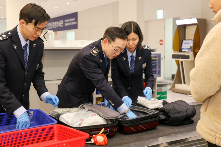 이명구(가운데) 관세청장이 22일 오전 인천국제공항 제1여객터미널에서 직접 여행자 휴대품을 검사하고 있다. 관세청 제공
