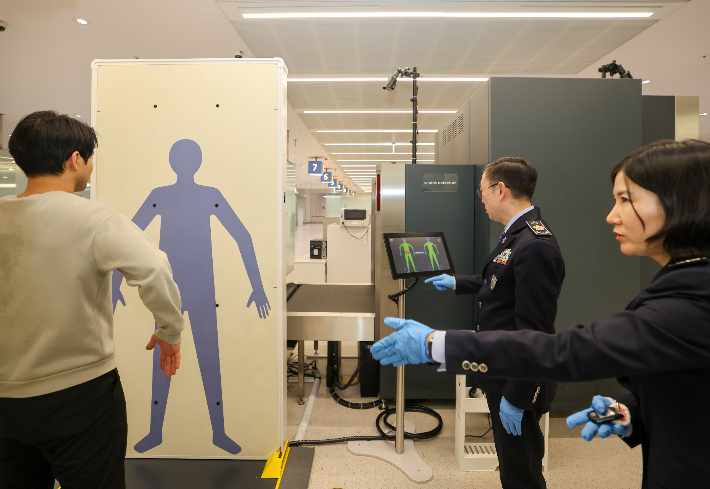 이명구(가운데) 관세청장이 22일 오전 인천국제공항 제1여객터미널에서 첨단 신변검색장비인 밀리미터파 등을 활용하여 직접 여행자 신변 검사업무를 수행하고 있다. 관세청 제공