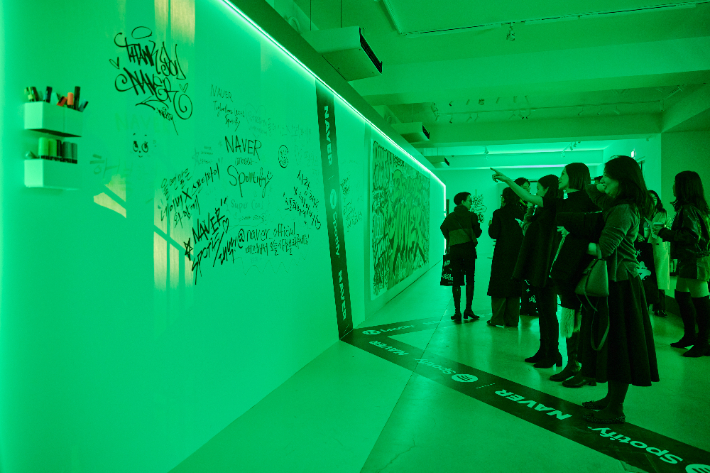 네이버-스포티파이 오프라인 팝업 스토어의 방문객이 '그래피티존'을 체험해 보며 몰입감 있게 콘텐츠를 경험하고 있다. 네이버 제공