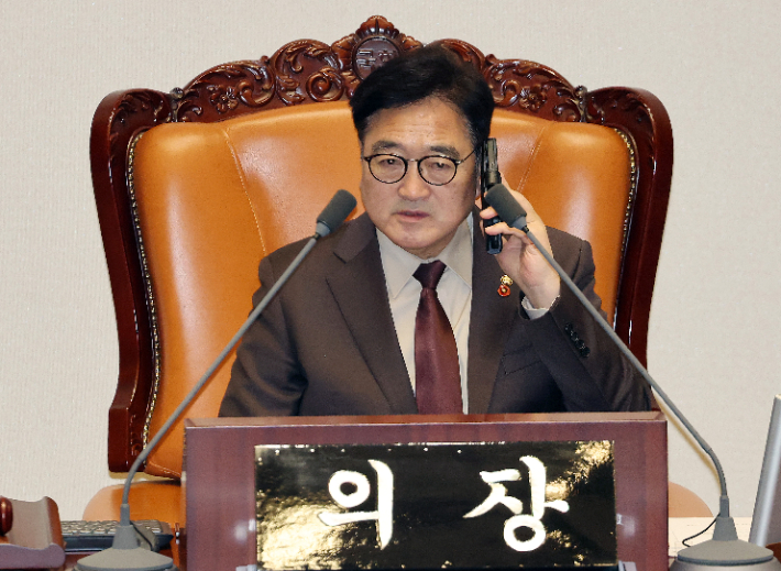 우원식 국회의장이 22일 국회에서 열린 12월 임시국회 본회의에 앞서 통화를 하고 있다. 연합뉴스