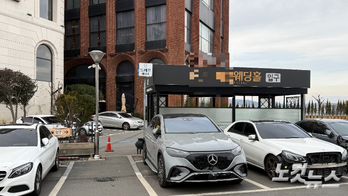 광주시 광산구 수완지구의 D 웨딩홀 입구 전경. 웨딩홀 진입로와 인접한 메르세데스-벤츠 신성자동차 서비스센터 주차장이 별다른 차단 없이 연결돼 있어, 하객 차량이 자연스럽게 주차장으로 유입될 수 있는 구조라는 지적이 나온다. 김한영 기자