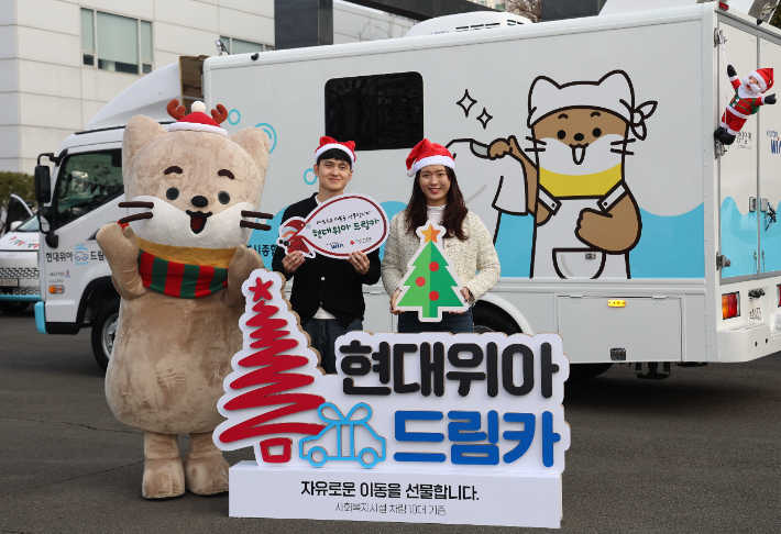 현대위아 직원들이 지난 23일 경상남도 창원시 현대위아 본사 앞에서 지역 사회복지기관 10곳에 선물할 '현대위아 드림카'와 함께 기념 사진을 찍고 있다. 현대위아 제공