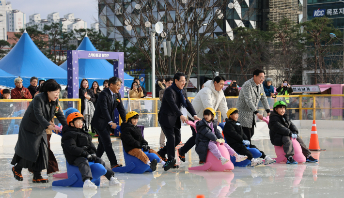 '전남OK도민광장 야외스케이트장·눈썰매장'이 24일 개장한 가운데 김영록 전남도지사와 전남개발공사 장충모 사장이 시설 어린이 70명을 초청해 눈썰매장을 밀고 있다. 전남개발공사 제공 