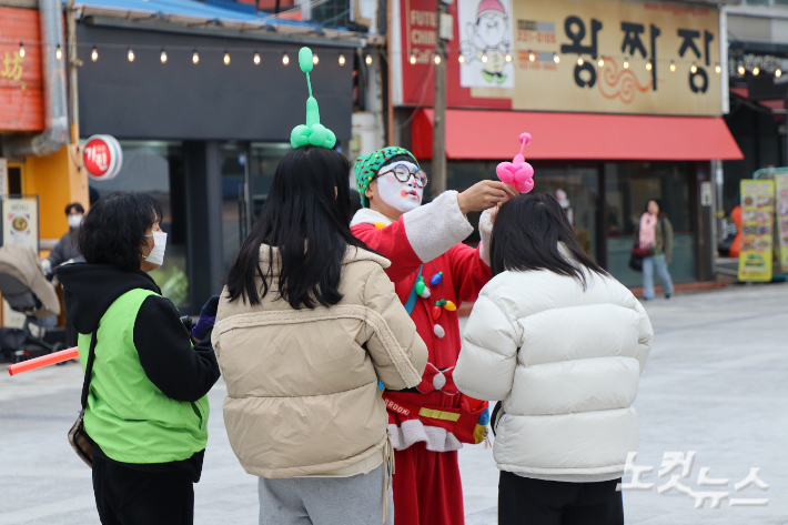 산타 복장을 한 성안길 상인회 관계자가 관객들에게 풍선 장식을 선물하고 있다. 임성민 기자 