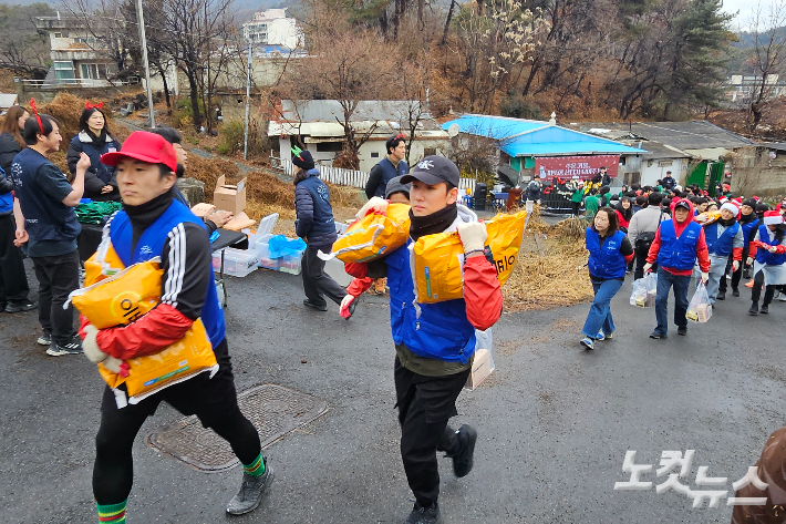 봉사자들이 연탄과 쌀, 크리스마스 선물을 전달하고 있다. 연탄은행은 이날 4천 장의 연탄을 에너지 취약계층에 전했다.