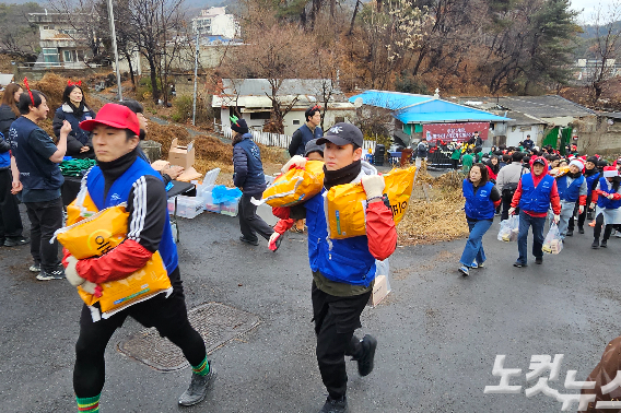 봉사자들이 연탄과 쌀, 크리스마스 선물을 전달하고 있다. 연탄은행은 이날 4천 장의 연탄을 에너지 취약계층에 전했다.