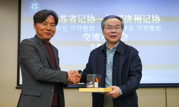 제주도기자협회 김익태 회장(왼쪽)과 중국 장쑤성기자협회 저우위에민 주석(오른쪽)이 지난 26일 신화보업미디어그룹 회의실에서 열린 교류간담회에서 악수하고 있다. 제주도기자협회  