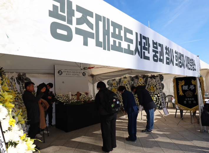 22일 광주 동구 5·18민주광장에 마련된 광주대표도서관 붕괴 참사 시민분향소에서 시민들이 참배하고 있다. 연합뉴스