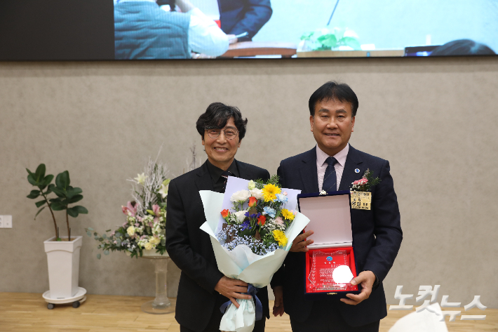 신임 회장 이태구 피택장로(왼쪽)가 임기를 마친 윤양일 장로(오른쪽)에게 공로패를 전달하고 있다. 최화랑 기자