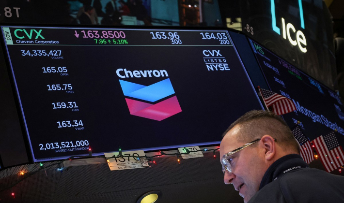 5일(현지시간) 미국 뉴욕증권거래소(NYSE)에서 일하는 트레이더들의 머리 위로 미국 석유기업 셰브런의 주가 현황이 비치고 있다. 연합뉴스