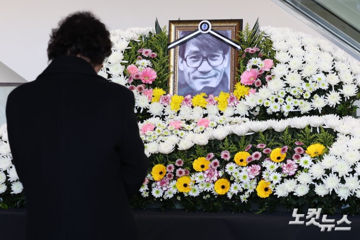 6일 서울 중구 충무로 서울영화센터에 마련된 배우 고 안성기를 추모하는 공간에서 조문객이 헌화 후 묵념하고 있다.