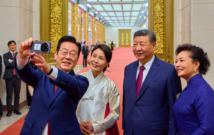 이재명 대통령 부부와 시진핑 국가주석 부부가 5일 중국 베이징 인민대회당에서 국빈만찬 후 샤오미폰으로 기념촬영을 하고 있다. 이 샤오미폰은 경주 정상회담 때 시 주석이 이 대통령에게 선물한 것이다. 연합뉴스