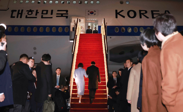 중국 방문 공식일정을 마친 이재명 대통령과 김혜경 여사가 7일 상하이 푸둥 공항 한국행 공군 1호기에 탑승하고 있다. 연합뉴스