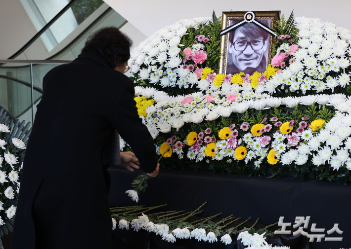 6일 서울 중구 충무로 서울영화센터에 마련된 배우 고 안성기를 추모하는 공간에서 조문객이 헌화하고 있다. 류영주 기자
