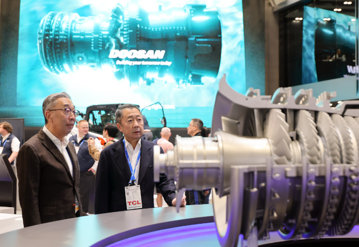 박정원 두산그룹 회장(오른쪽)과 박지원 그룹부회장(왼쪽)이 7일(현지시간) 미국 라스베이거스에서 열리고 있는 CES 2026 현장에서 두산 부스에 전시된 가스터빈 모형을 살펴보고 있다. 두산그룹 제공