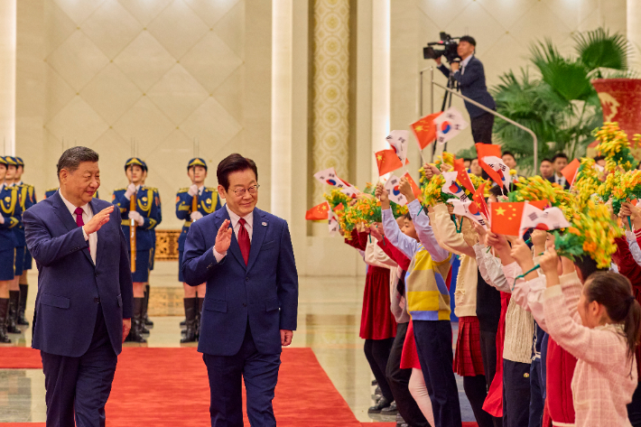 이재명 대통령(오른쪽)과 시진핑 중국 국가주석이 5일 베이징 인민대회당에서 열린 이 대통령 공식환영식이 끝난 뒤 어린이들을 향해 손을 흔들고 있다. 연합뉴스