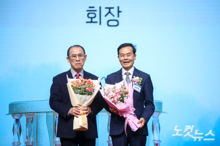이임하는 명예회장 황인철 목사(왼쪽)와 취임한 대표회장 김동하 목사(오른쪽)가 꽃다발을 들고 기념촬영을 하고 있다. 최화랑 기자