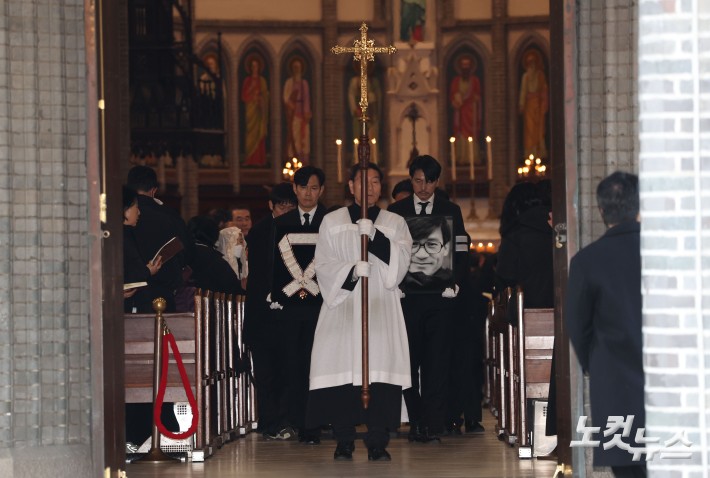 9일 오전 서울 중구 명동성당에서 열린 故 안성기의 장례 미사가 끝난 뒤 영결식을 위해 고인의 영정과 금관문화훈장을 든 배우 정우성, 이정재가 영결식장으로 향하고 있다.
