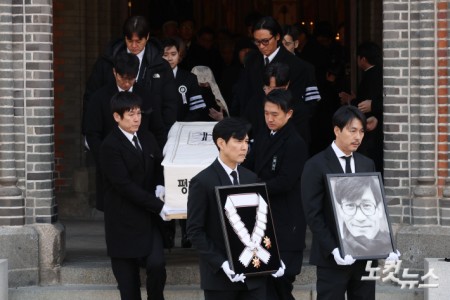 9일 오전 서울 중구 명동성당에서 열린 故 안성기의 장례 미사가 끝난 뒤 영결식을 위해 고인의 영정과 금관문화훈장을 든 배우 정우성, 이정재가 영결식장으로 향하고 있다.