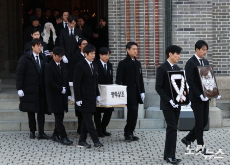 9일 오전 서울 중구 명동성당에서 열린 故 안성기의 장례 미사가 끝난 뒤 영결식을 위해 고인의 영정과 금관문화훈장을 든 배우 정우성, 이정재가 영결식장으로 향하고 있다.