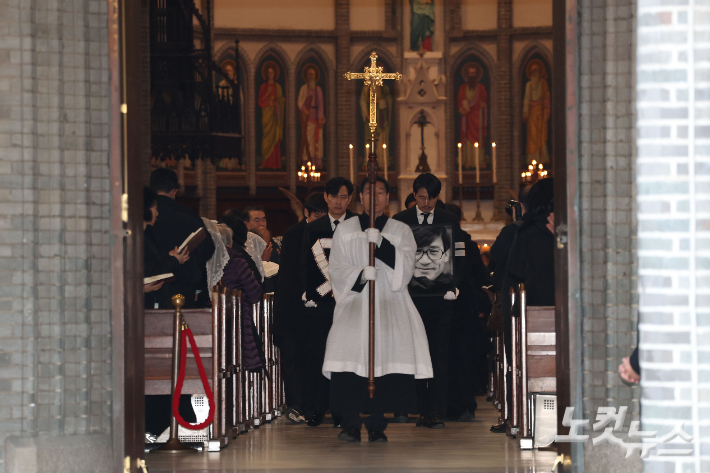 9일 오전 서울 중구 명동성당에서 열린 故 안성기의 장례 미사가 끝난 뒤 영결식을 위해 고인의 영정과 금관문화훈장을 든 배우 정우성, 이정재가 영결식장으로 향하고 있다. 류영주 기자