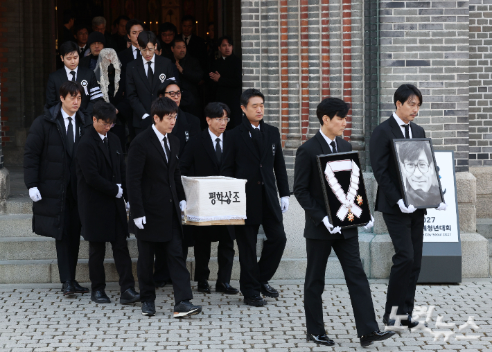 9일 오전 서울 중구 명동성당에서 열린 故 안성기의 장례 미사가 끝난 뒤 영결식을 위해 고인의 영정과 금관문화훈장을 든 배우 정우성, 이정재가 영결식장으로 향하고 있다. 류영주 기자