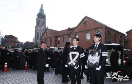 9일 오전 서울 중구 명동성당에서 열린 故 안성기의 영결식에서 배우 정우성, 이정재가 고인의 영정과 금관문화훈장을 들고 있다.