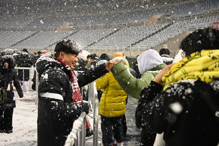 부천FC1995의 승강 PO 1차전이 폭설로 연기된 후 돌아가는 시민들과 조용익 부천시장이 주먹인사를 나누고 있다. 부천시 제공