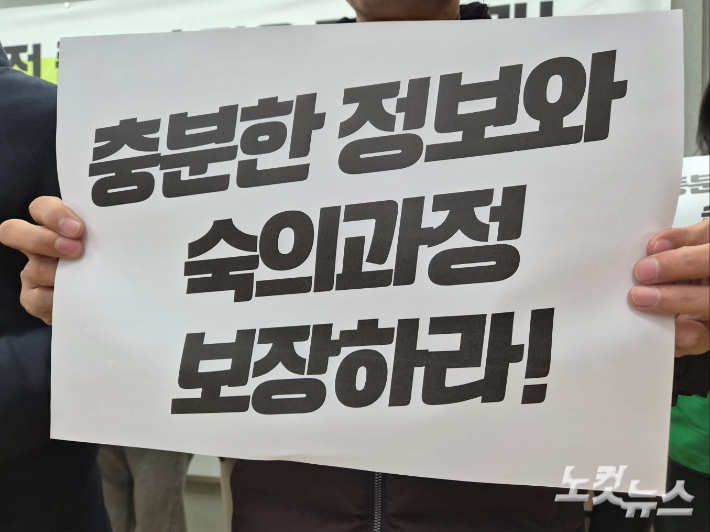 한 참석자가 '충분한 정보와 숙의과정 보장하라'고 적힌 손피켓을 들고 있다. 김정남 기자