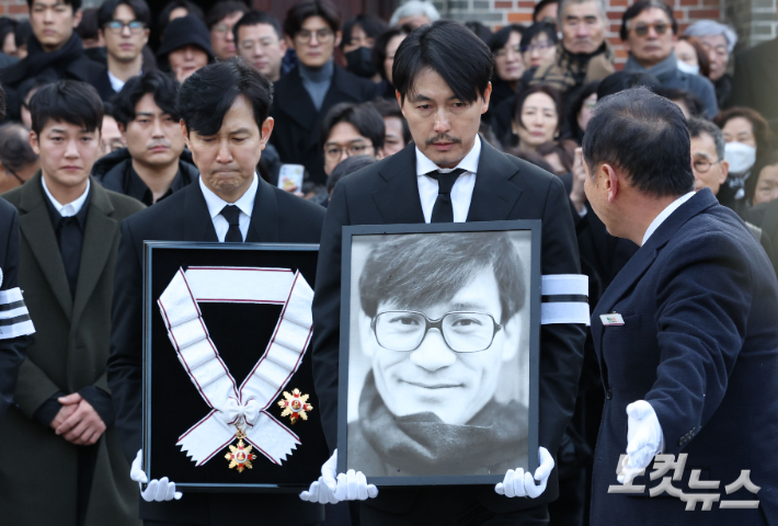 9일 오전 서울 중구 명동성당에서 열린 故 안성기의 장례 미사가 끝난 뒤 영결식을 위해 고인의 영정과 금관문화훈장을 든 배우 정우성, 이정재가 영결식장으로 향하고 있다. 류영주 기자